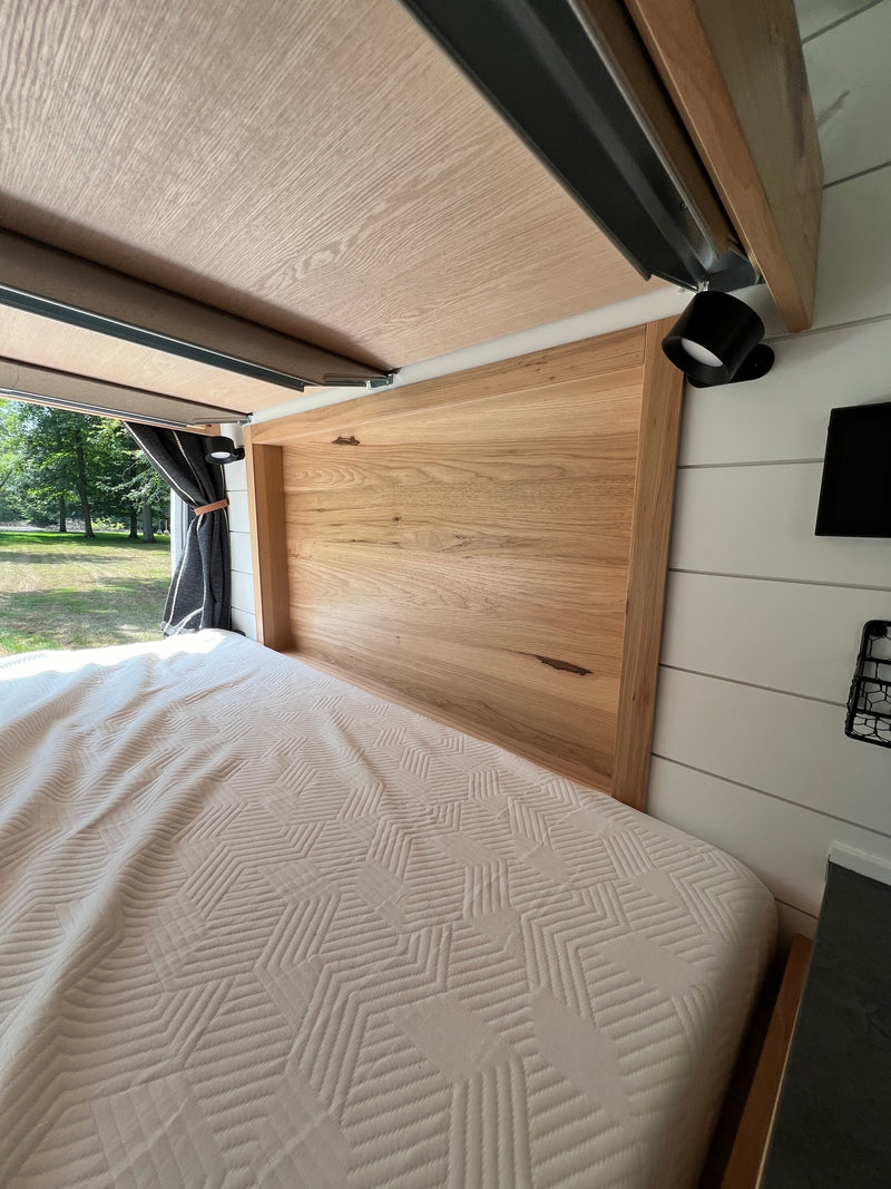  and comfortable black leather seating.|Inside a comfortable RV rental: modern bunk beds with light wood accents and a tranquil park view from the window.|RV rental features stacked bunk beds — photo 20