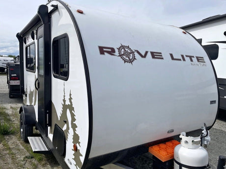  with trees and a house in the background.|RV rental interior: compact kitchen with sink