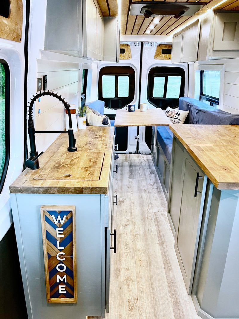  and warm wood accents. Ready for adventure!|Inside a stylish rv rental: a light-filled camper van with a compact kitchen — photo 10