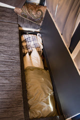 RV rental: Open under-seat storage in a camper, revealing neatly folded blankets and bedding. Ideal for travel organization.