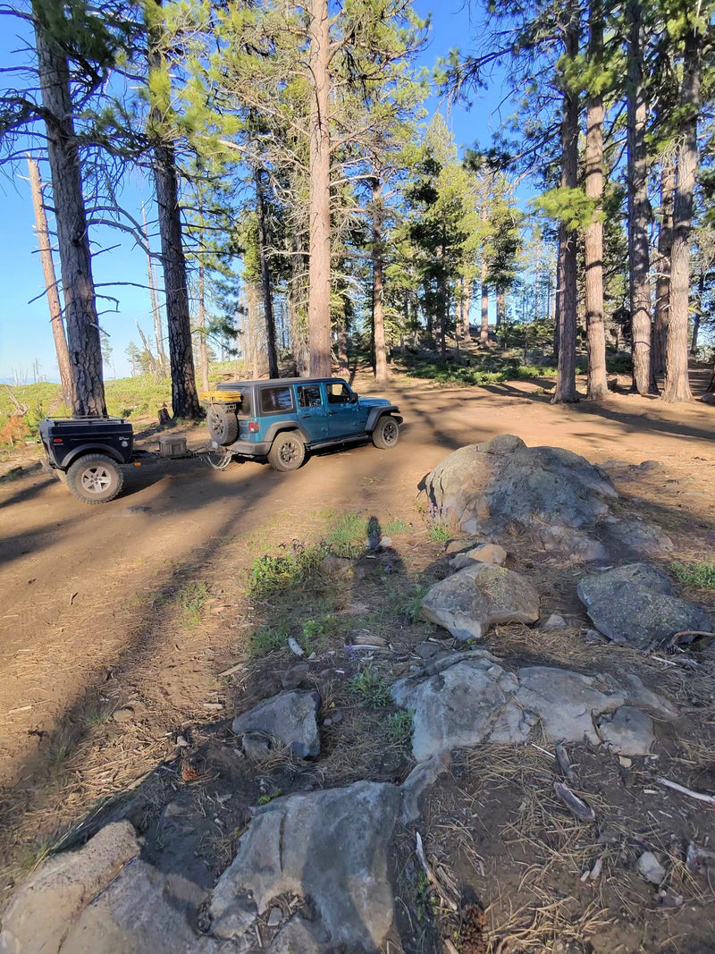 Blue Jeep & off-road trailer in a forest. Experience off-road camping; perfect RV rental for adventure! — photo 2