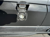 RV rental shore power inlet for external electrical hookup. The open cover displays warnings for safe cable connection/disconnection.