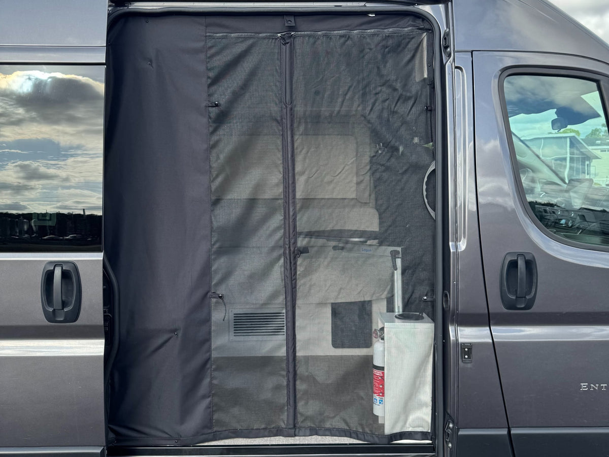  is parked outdoors on a sunny day.|Frontal view: dark gray Ram ProMaster van — photo 7