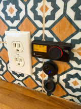 RV rental amenities: Wall outlet, Eberspächer climate control (52°F, 80min runtime), and dual USB charger on patterned tiles.