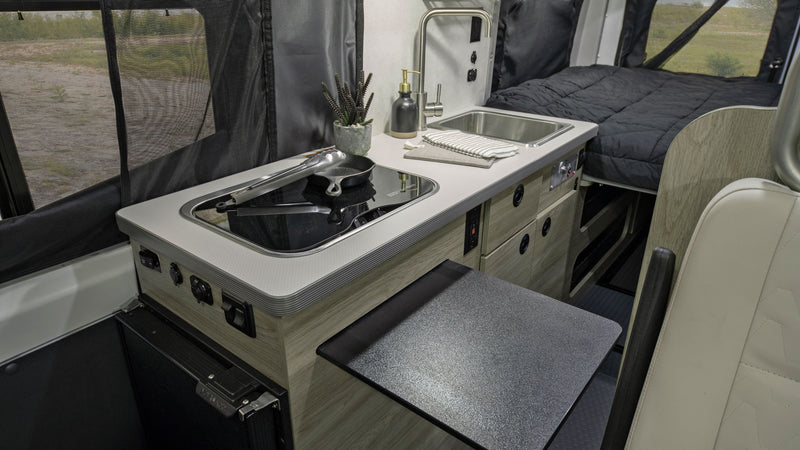  set against scenic mountains.|Two women relaxing outside a white pop-top campervan — photo 2