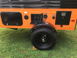 Side of an orange RV rental featuring fresh/city water hookups, an outdoor shower, storage, and a tire.