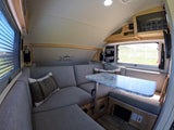 Cozy RV rental interior: U-shaped dinette, marble-top table, "Life is for adventure" decal, perfect for travel and comfort.