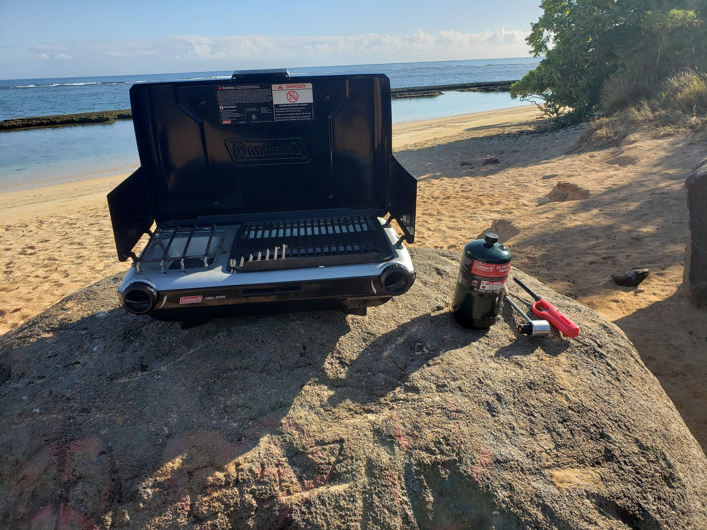 Beachside Coleman grill & propane tank on a rock, ideal for outdoor cooking during an RV rental trip. — photo 16