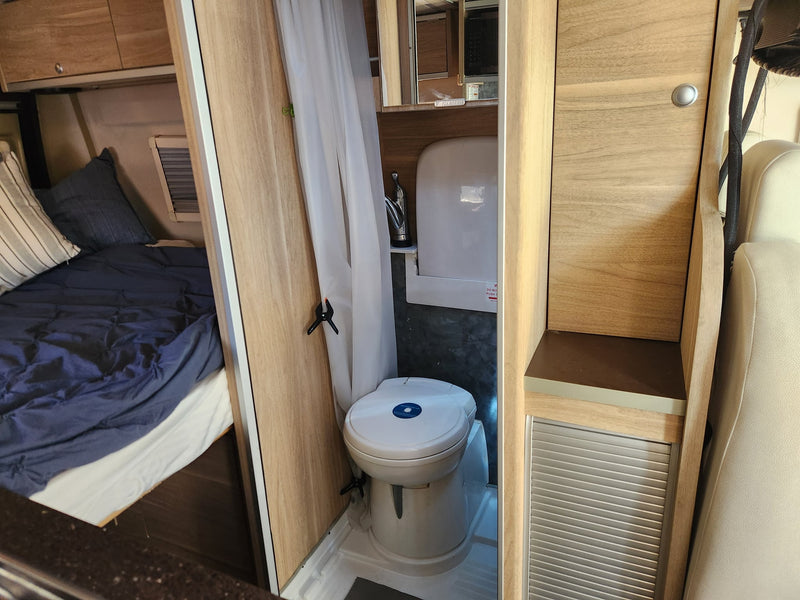  and wood finishes ready for your next trip.|Cozy rv rental interior featuring a dining area with white seating — photo 5