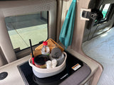 RV rental kitchen counter with a Dometic stovetop, a basket of campfire essentials, and a teal towel hanging nearby.