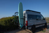Adventure-ready RV rental van with surfboard, bike, and a sleepy dog. Perfect for outdoor travel and van life!
