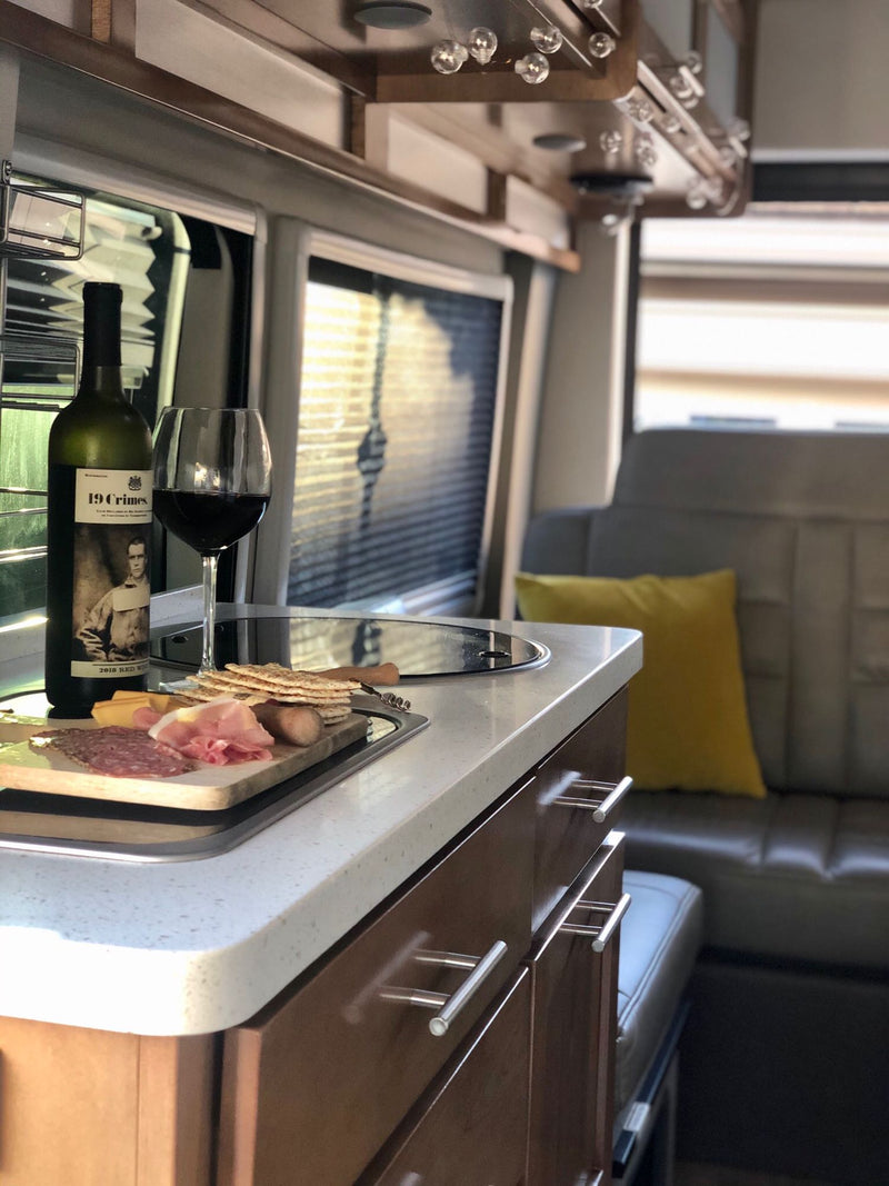 revealing a cozy bed and storage. Camping chairs invite outdoor relaxation.|Woman sips coffee in RV rental — photo 9