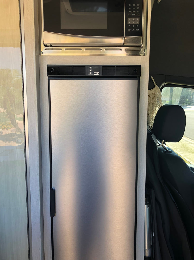 showing safety warnings and a yellow propane cap with an on/off switch.|Inside an RV rental: a built-in stainless steel microwave over a Norcold refrigerator — photo 3
