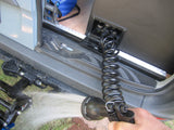 RV rental convenience: A person demonstrates the integrated water system, spraying water from a coiled hose outside the van.
