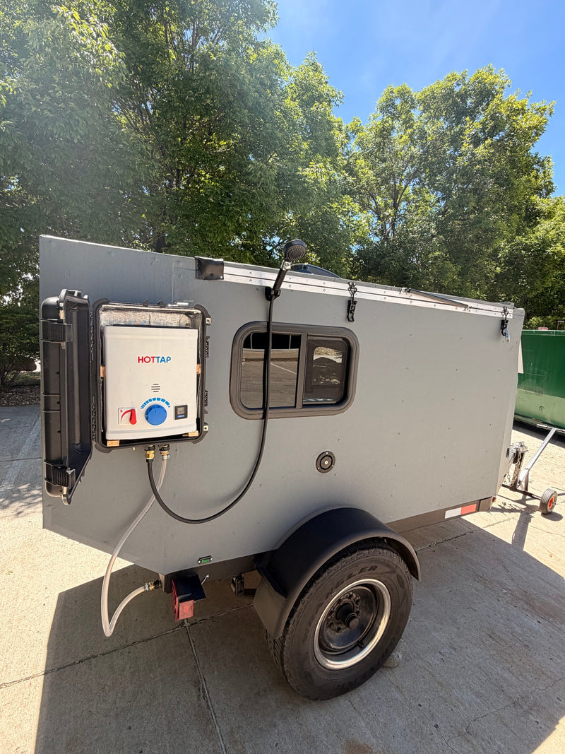 This gray camper trailer, perfect for rv rental, features an external HOTTAP portable shower system for outdoor convenience. — photo 5
