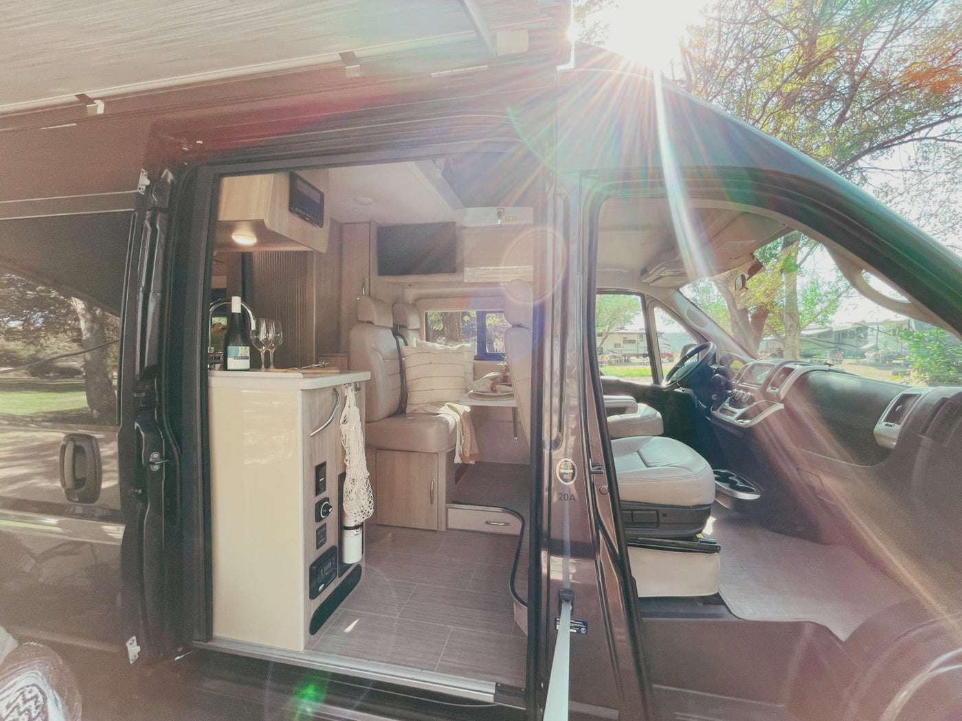  and a TV.|Experience an RV rental: a plush bed offers panoramic desert and mountain views. Ideal for a scenic road trip adventure.|Inside a compact RV rental bathroom: features a toilet — photo 6