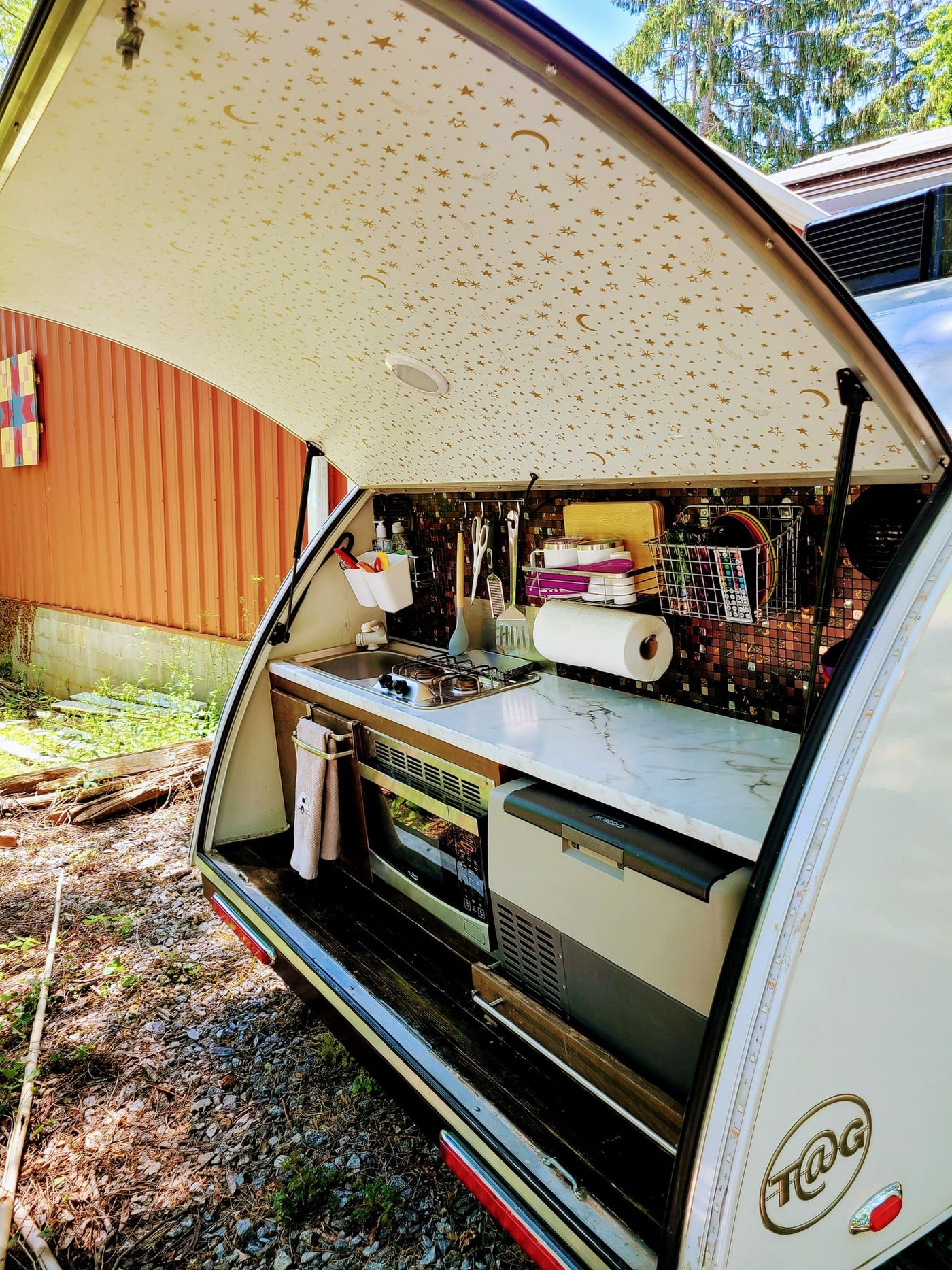  and window view of nature.|Inside a cozy RV rental: a bed with blue and purple covers — photo 5