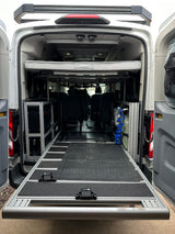 Adventure-ready RV rental: Van interior showing a pull-out bed, modular storage, and a practical rear slide-out for gear.