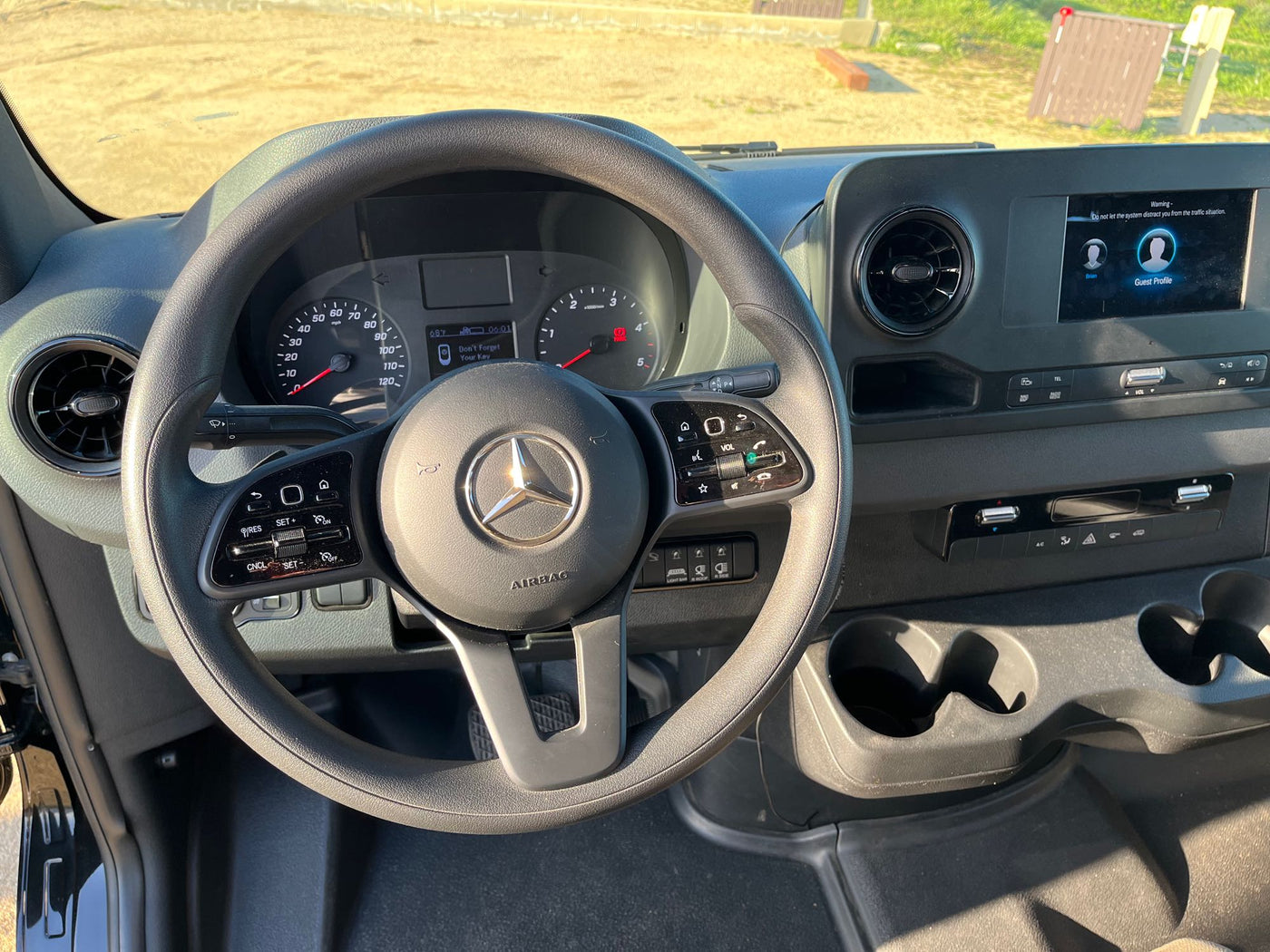 RV rental interior: driver's view of a Mercedes cockpit. Dashboard shows 'Don't Forget Your Key,' plus an infotainment screen. — photo 6