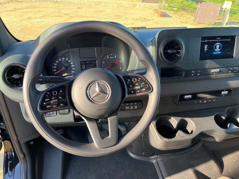RV rental interior: driver's view of a Mercedes cockpit. Dashboard shows 'Don't Forget Your Key,' plus an infotainment screen. — photo 6