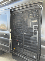 RV rental ready: gray van's side door open, revealing a black mesh bug screen. Organized interior shelves & gear visible for trips.