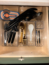 RV rental kitchen drawer: neatly organized with measuring cups, utensils, and flatware in clear bins.