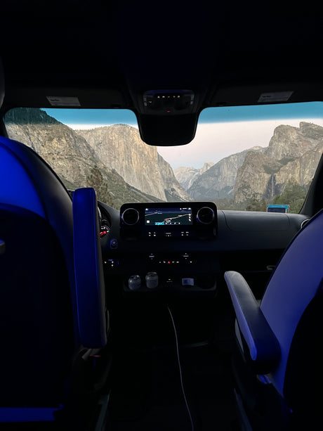 Iconic Yosemite views from a comfy RV rental. Dashboard, navigation, and granite giants fill the windshield.