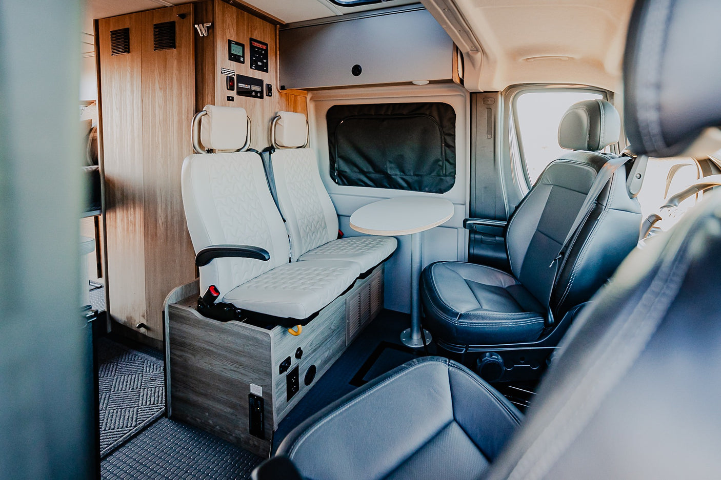 Step inside this RV rental! Comfortable seating, a versatile table, and integrated controls make it perfect for travel.