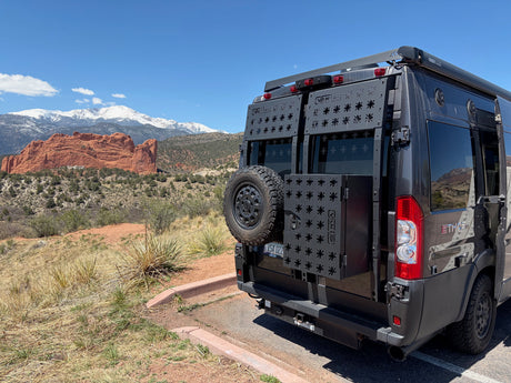 Adventure-ready rv rental camper van overlooking Colorado's iconic red rocks & snowy Pikes Peak on a sunny day.