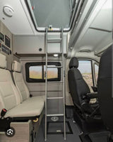 RV rental interior: A camper van with a ladder leading to an upper bunk, comfortable seating, and a ceiling skylight.
