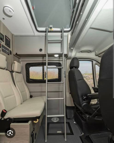 RV rental interior: A camper van with a ladder leading to an upper bunk, comfortable seating, and a ceiling skylight.