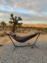 Enjoying a desert sunset in a cozy hammock with Joshua trees. Perfect relaxation spot for your RV rental adventure!