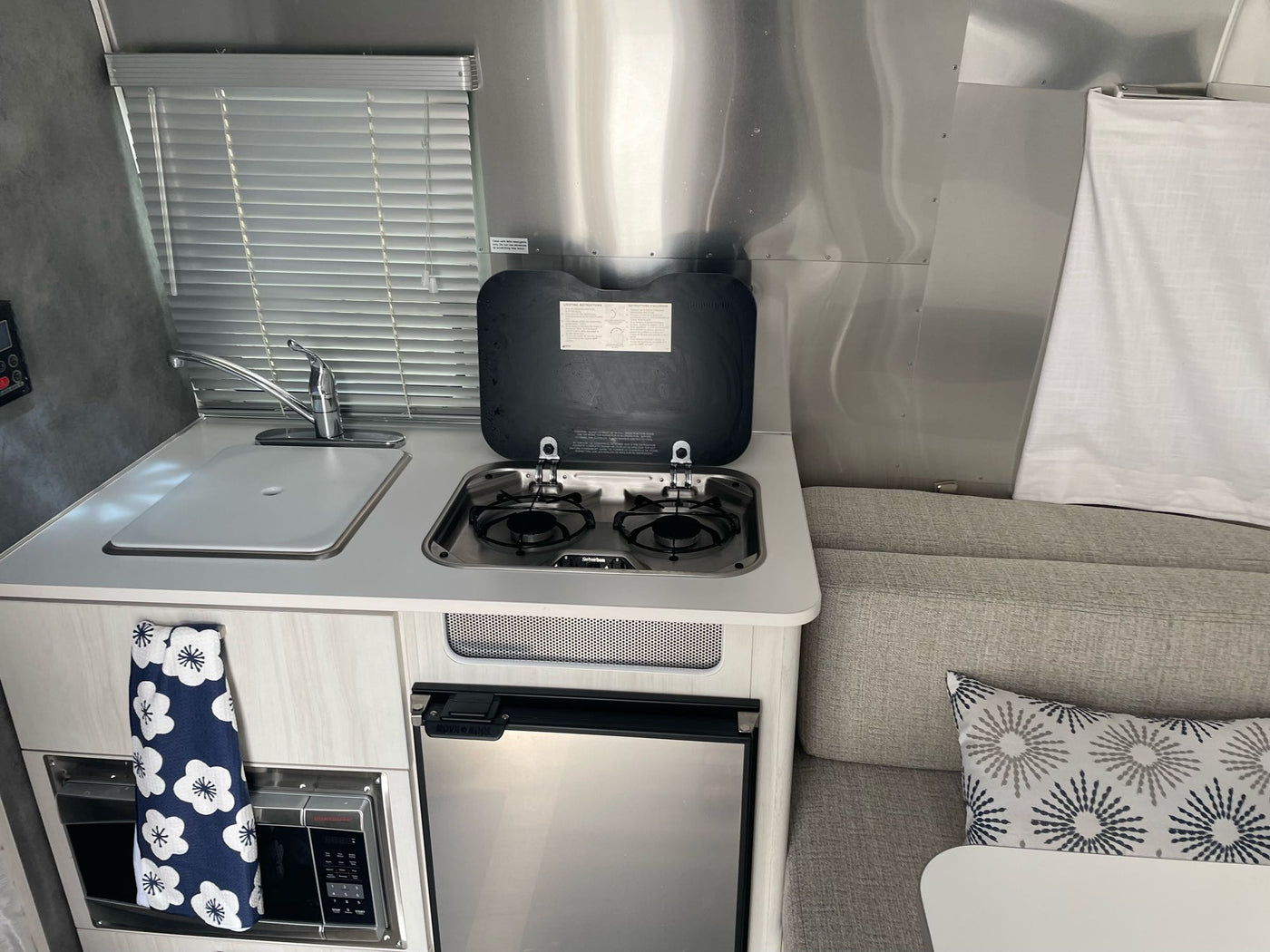  and comfortable upholstered seating.|Inside an RV rental: a comfy Airstream bedroom with metallic walls — photo 6