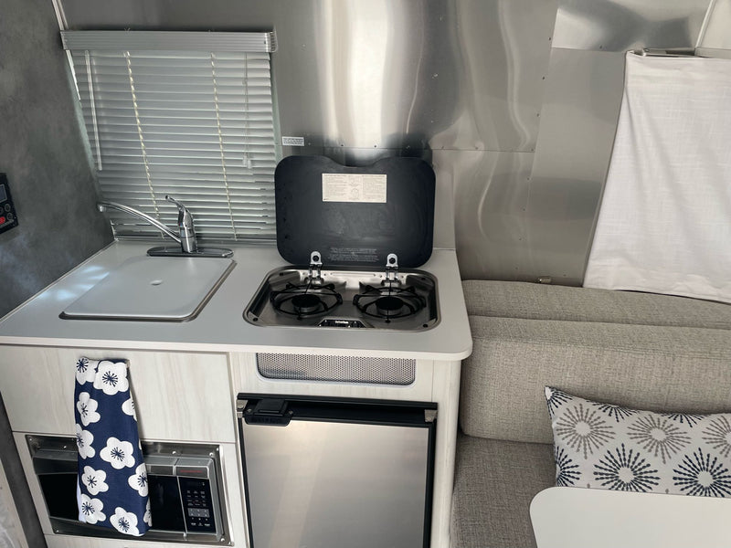  and comfortable upholstered seating.|Inside an RV rental: a comfy Airstream bedroom with metallic walls — photo 6