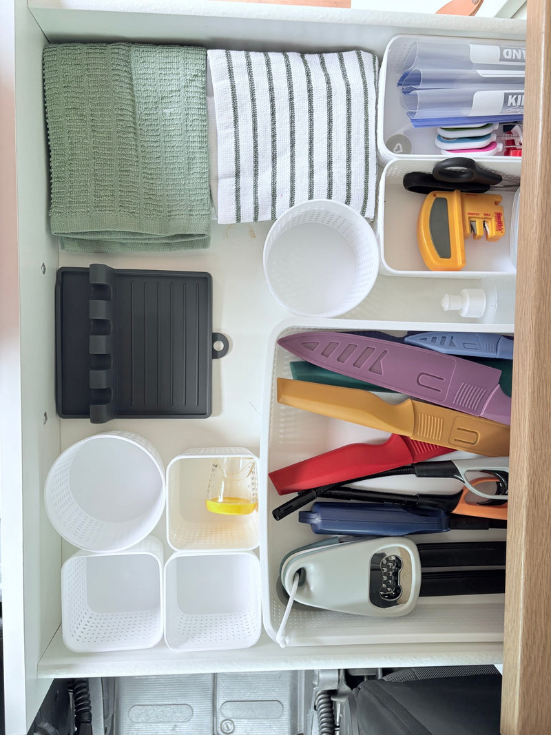 RV rental kitchen drawer organization: towels, cooking tools, and storage bins neatly arranged for efficient space utilization. — photo 8