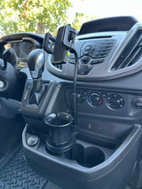 RV rental interior with a phone mount in a cup holder, dashboard, gear shift, and USB port visible.