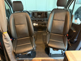 RV rental: Spacious front cabin with comfortable black leather swivel seats for driver and passenger, and the dashboard.