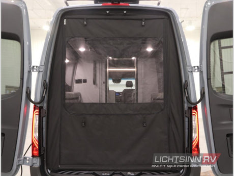 Rear view of an RV rental with open doors, featuring a black mesh screen for ventilation and privacy. Shows the camper's interior.