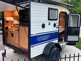Compact Sunray Classic teardrop RV rental with an outdoor kitchen setup, perfect for your next camping adventure.