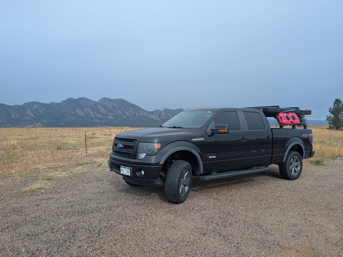  and padded ceiling.|This robust truck camping setup with a Roofnest rooftop tent provides an alternative to an rv rental for outdoor overlanding adventures.|Black Ford F-150 adventure truck with rooftop tent and gear on a gravel road. Perfect rv rental for rugged mountain expeditions.|ROOFNEST cargo on an RV rental — photo 6