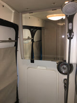 RV rental shower area: Compact bathroom with a modern shower head, Moen controls, and mirror showing interior details.