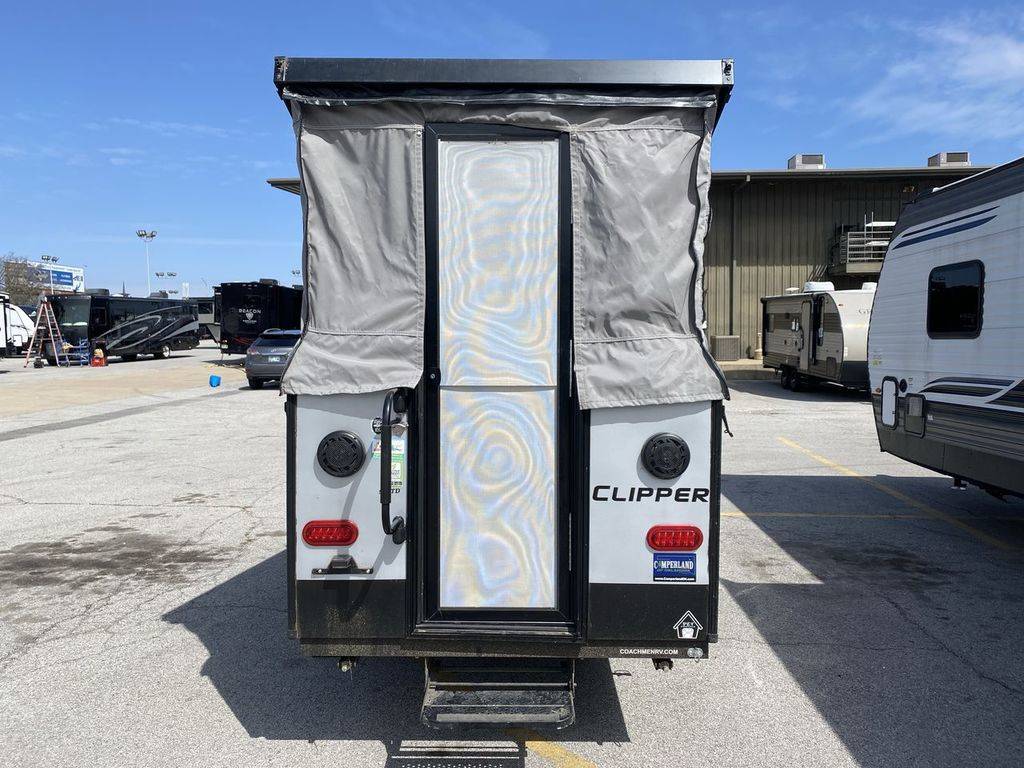  and counter space.|Compact RV rental interior featuring a cozy bed with patterned bedding — photo 7