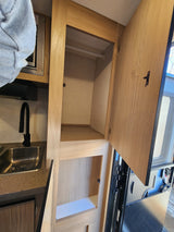 RV rental interior: A practical kitchen with sink and microwave, plus ample open closet storage space.