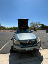 A silver Subaru Forester with an open rooftop tent, ready for adventure. Perfect for camping or as an RV rental.