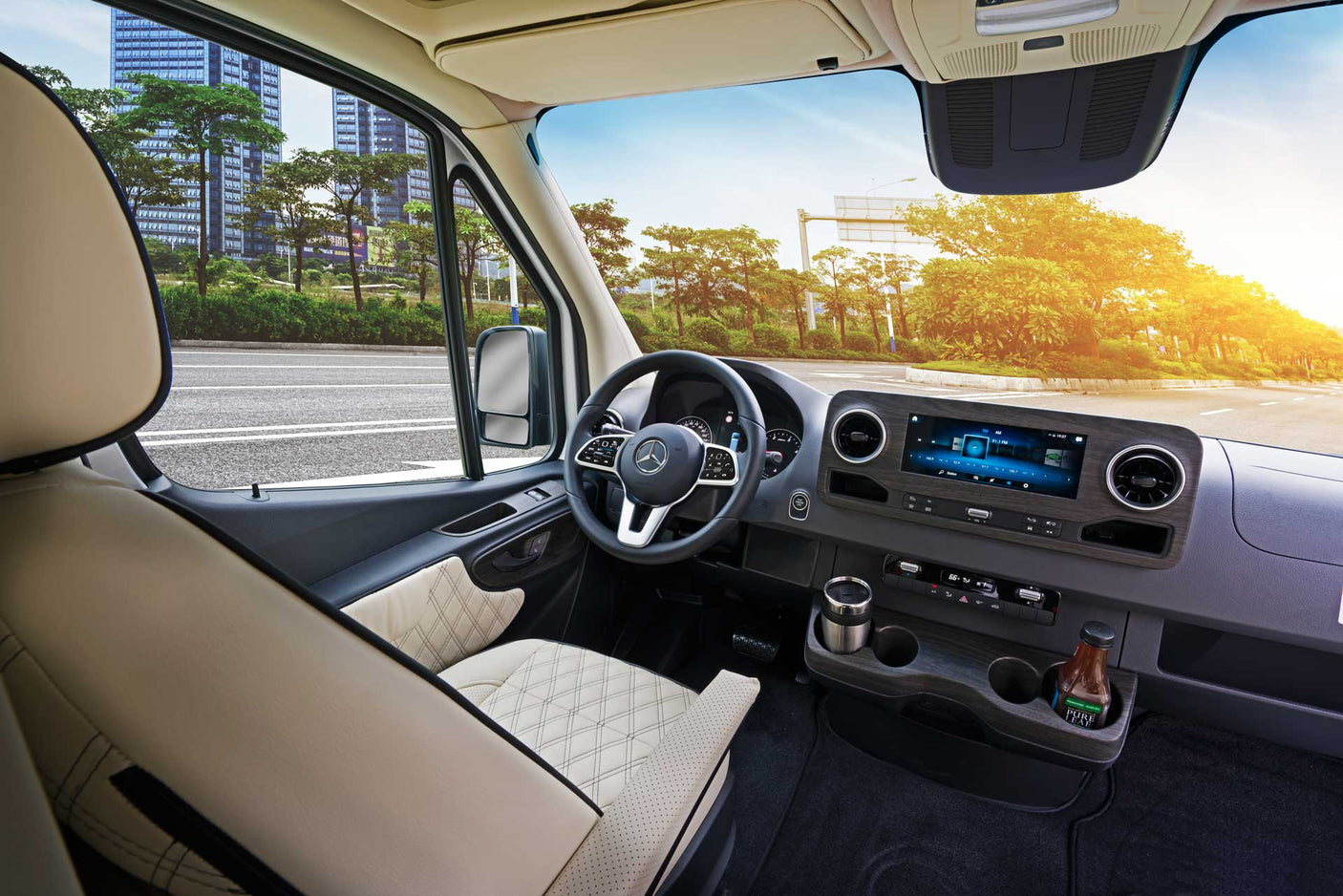 RV rental: Spacious Mercedes-Benz camper van interior with modern dashboard, plush seats, and a bright road ahead.