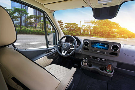 RV rental: Spacious Mercedes-Benz camper van interior with modern dashboard, plush seats, and a bright road ahead.