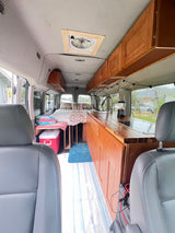 Experience mobile living in this RV rental! Van conversion with bed, kitchen, custom cabinetry, and ceiling fan.