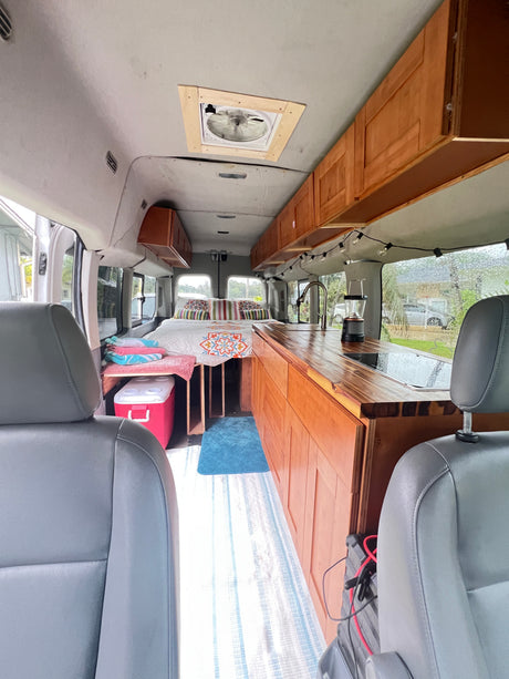 Experience mobile living in this RV rental! Van conversion with bed, kitchen, custom cabinetry, and ceiling fan.