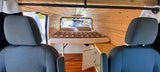 RV rental camper van interior: cozy wood paneling, comfortable bed, and clever storage for your next road trip.