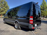 Sleek black Mercedes-Benz Sprinter van with tinted windows, perfect for an RV rental adventure. Parked outside.